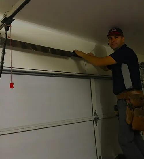Technician repairing a garage door by RL Garage Door Repair