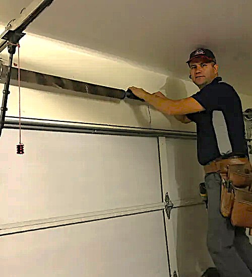 Technician repairing a garage door by RL Garage Door Repair